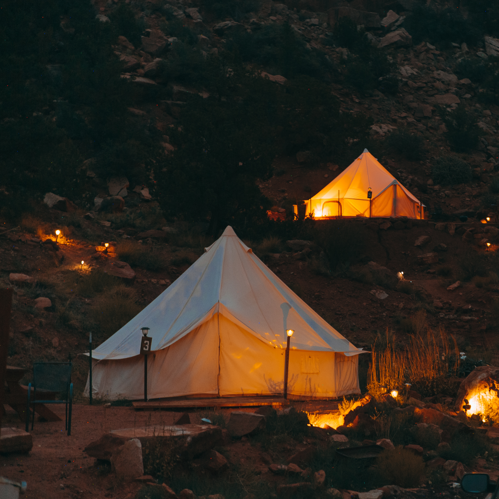 Belle Glamping Tent with light on in the dark under the bright stars in Zion Utah