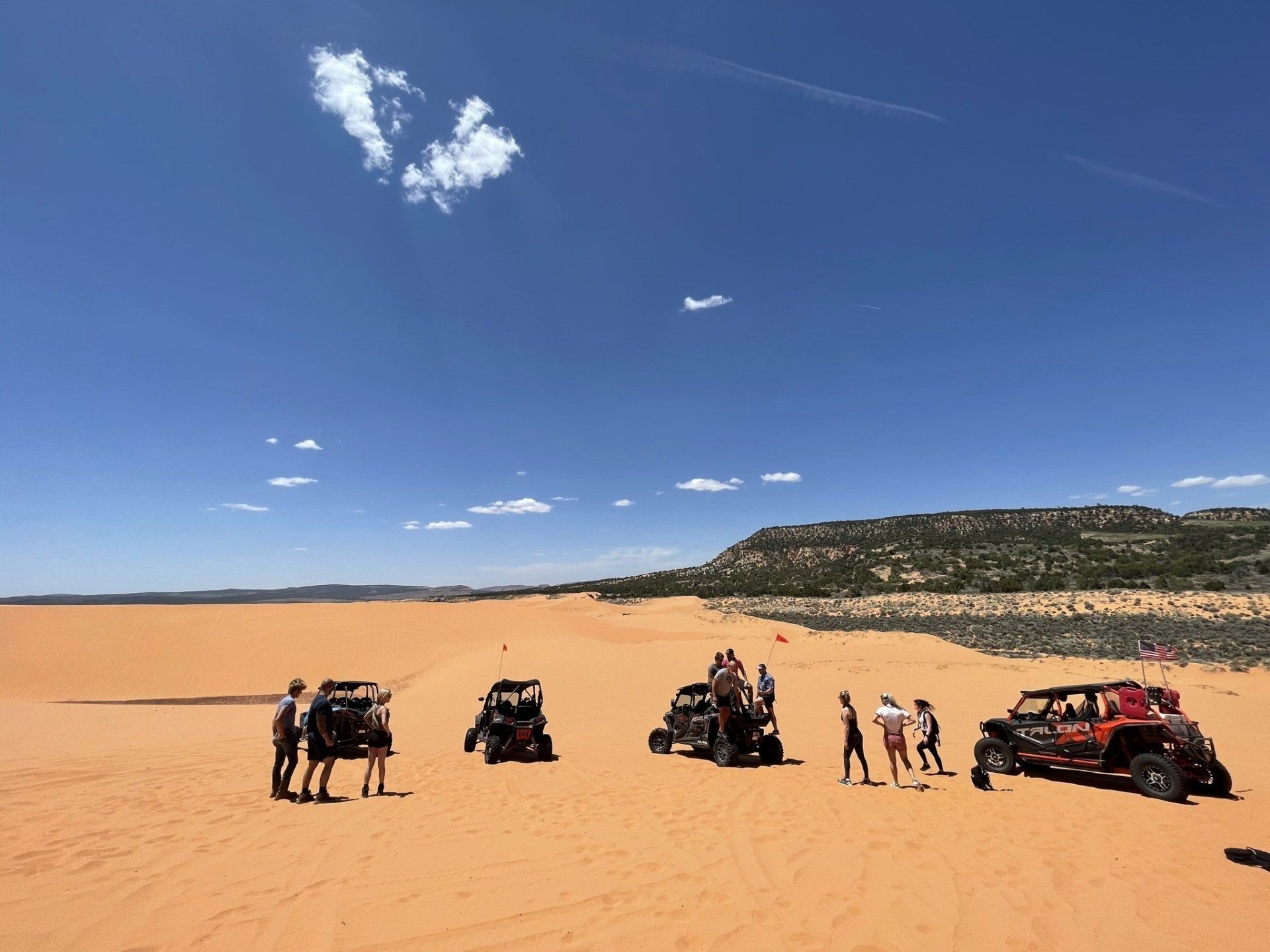 Group of adventurers preparing for a buggy ride on the expansive Coral Pink Sand Dunes.