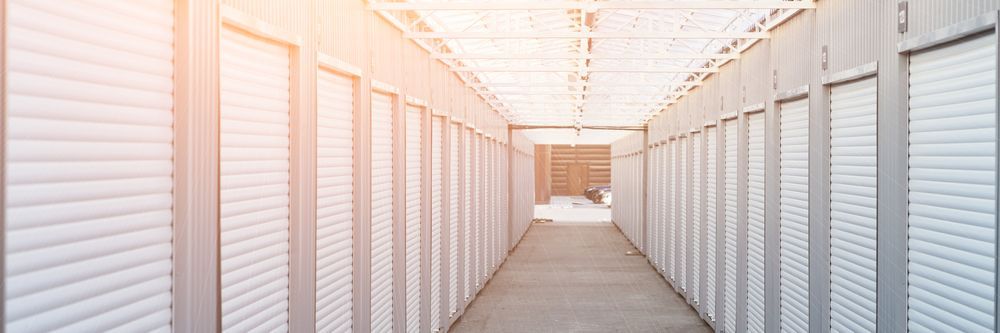Long Hallway Lined With White Storage Units, Sunlight Streams From the End — Gympie Southside Mini Storage in Southside, QLD