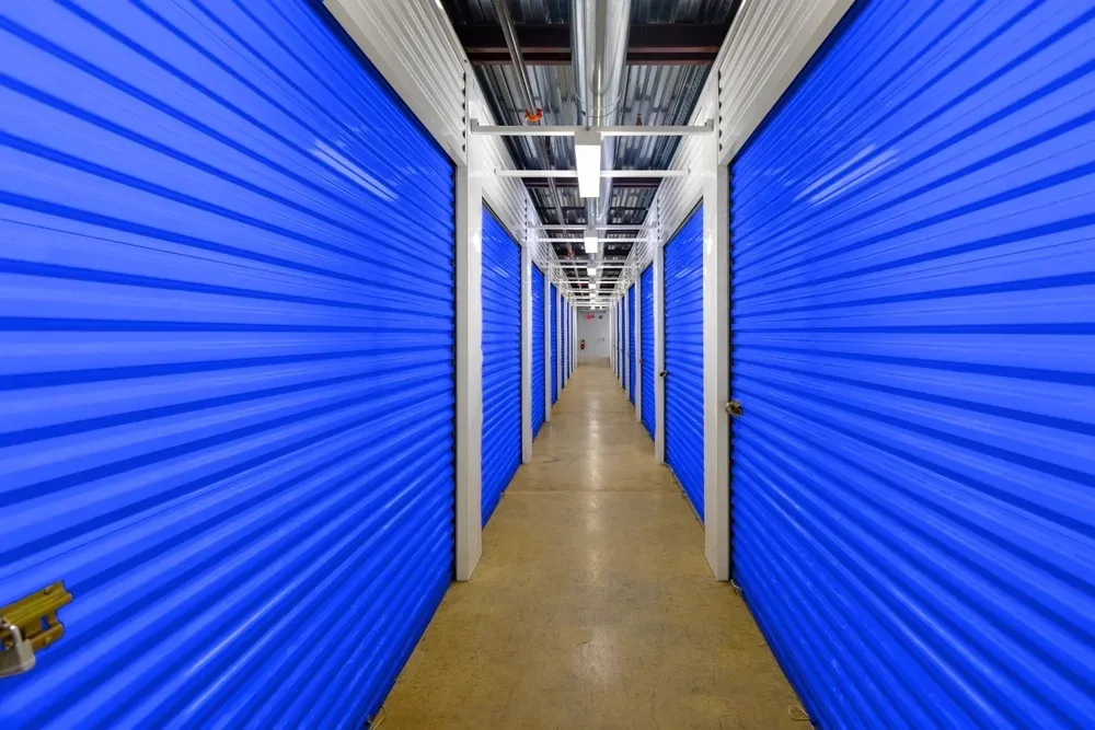 Long hallway of blue storage unit doors. — Gympie Southside Mini Storage in Southside, QLD