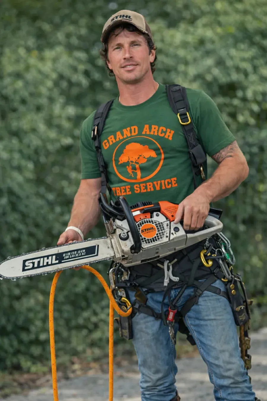 Man in safety gear holding a chainsaw.