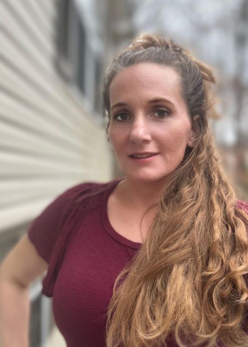 Man in safety gear holding a chainsaw.