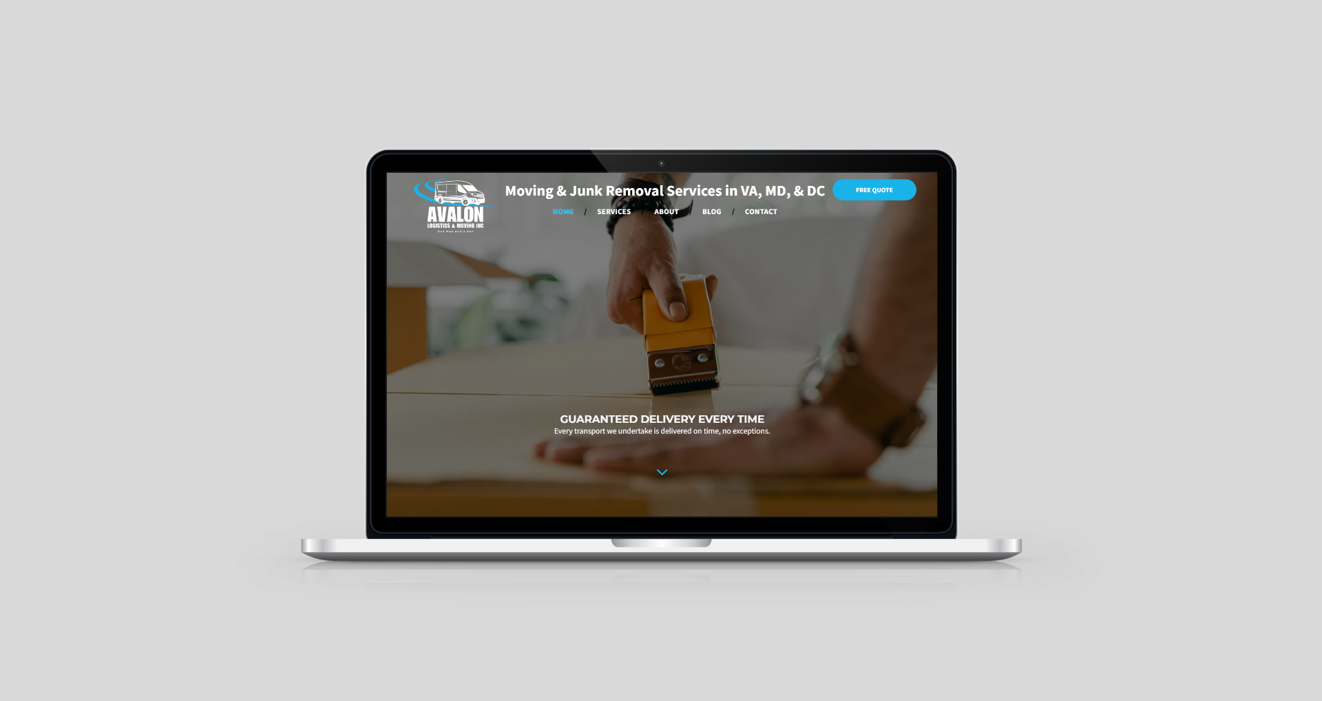 Laptop displaying a website with a logo, website address, and person holding a device on a desk.