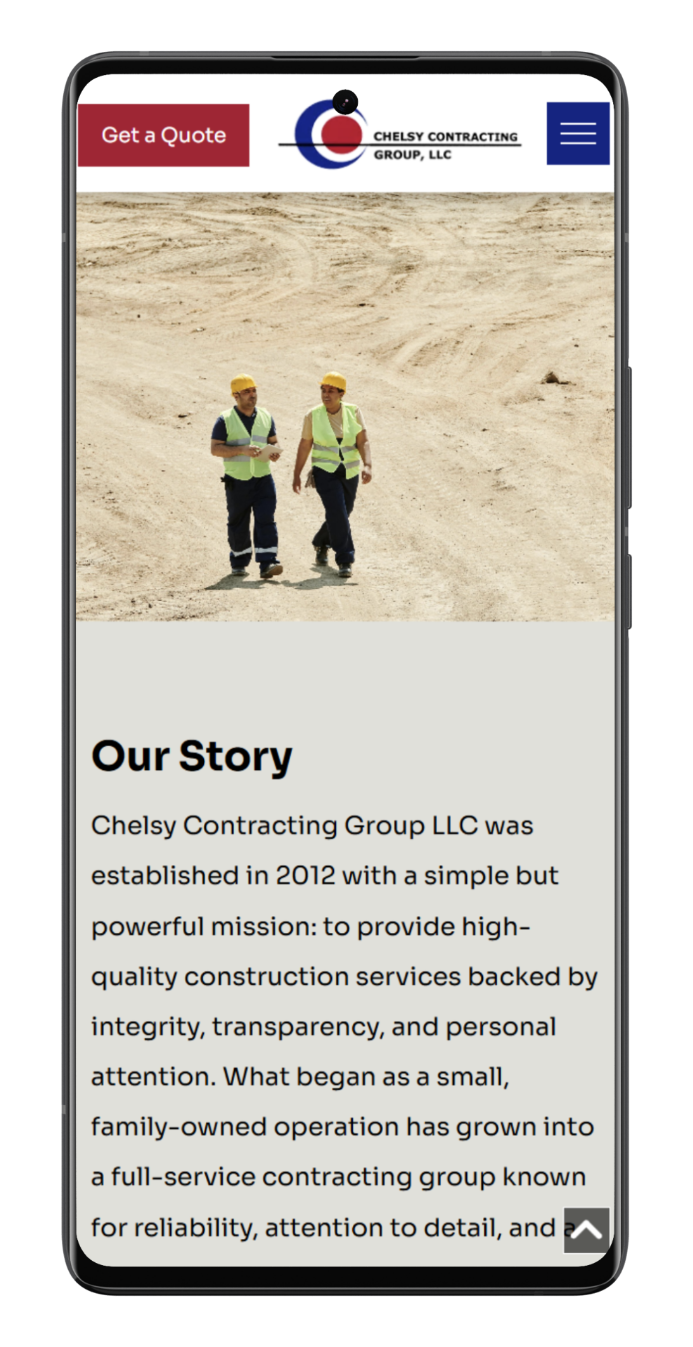 Two construction workers walking on a dirt road, company website on phone.