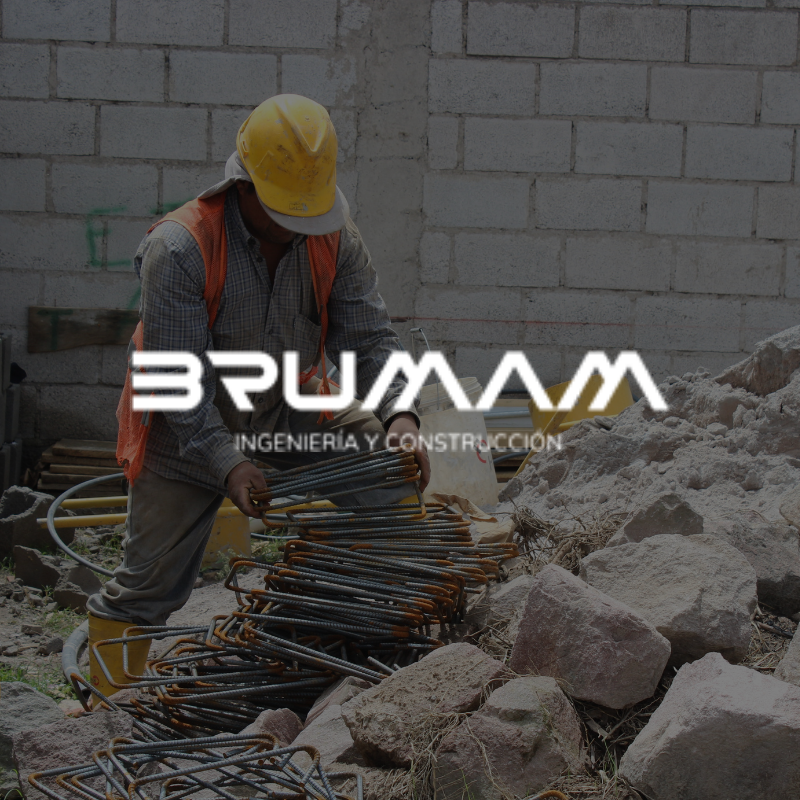 A man wearing a hard hat is working on a construction site for brumam ingenieria y construccion