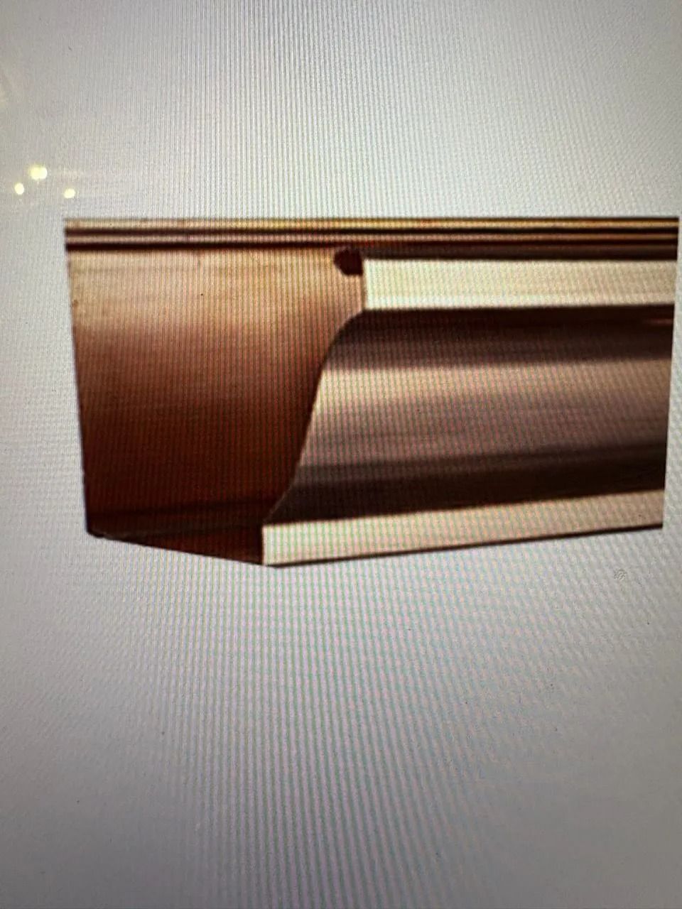 Woman in straw hat smiles, holding wine glass near a lake.