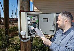 Technician Taking Reading Of Electric Meter - Electrical Contractor in Dewitt, MI