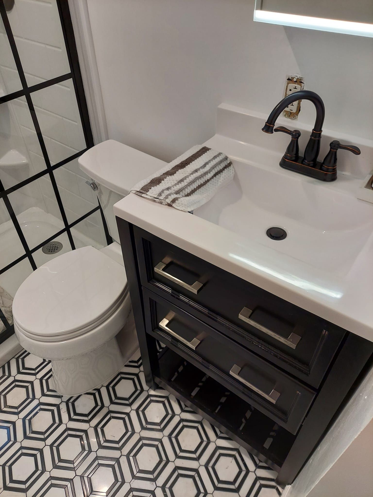 A bathroom with a toilet , sink , and mirror.
