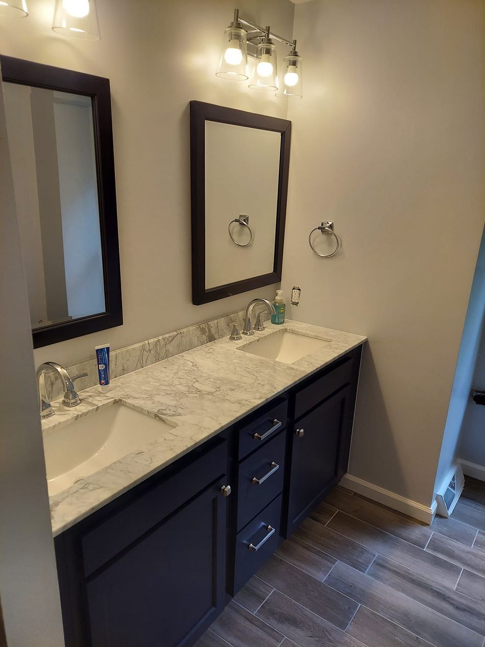 A bathroom with two sinks and two mirrors.
