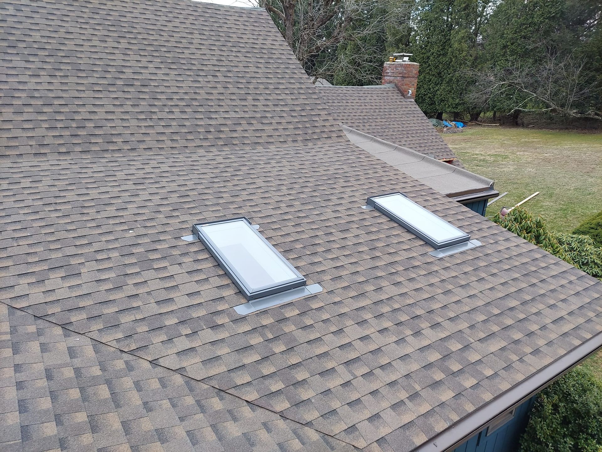 There are two skylights on the roof of a house.