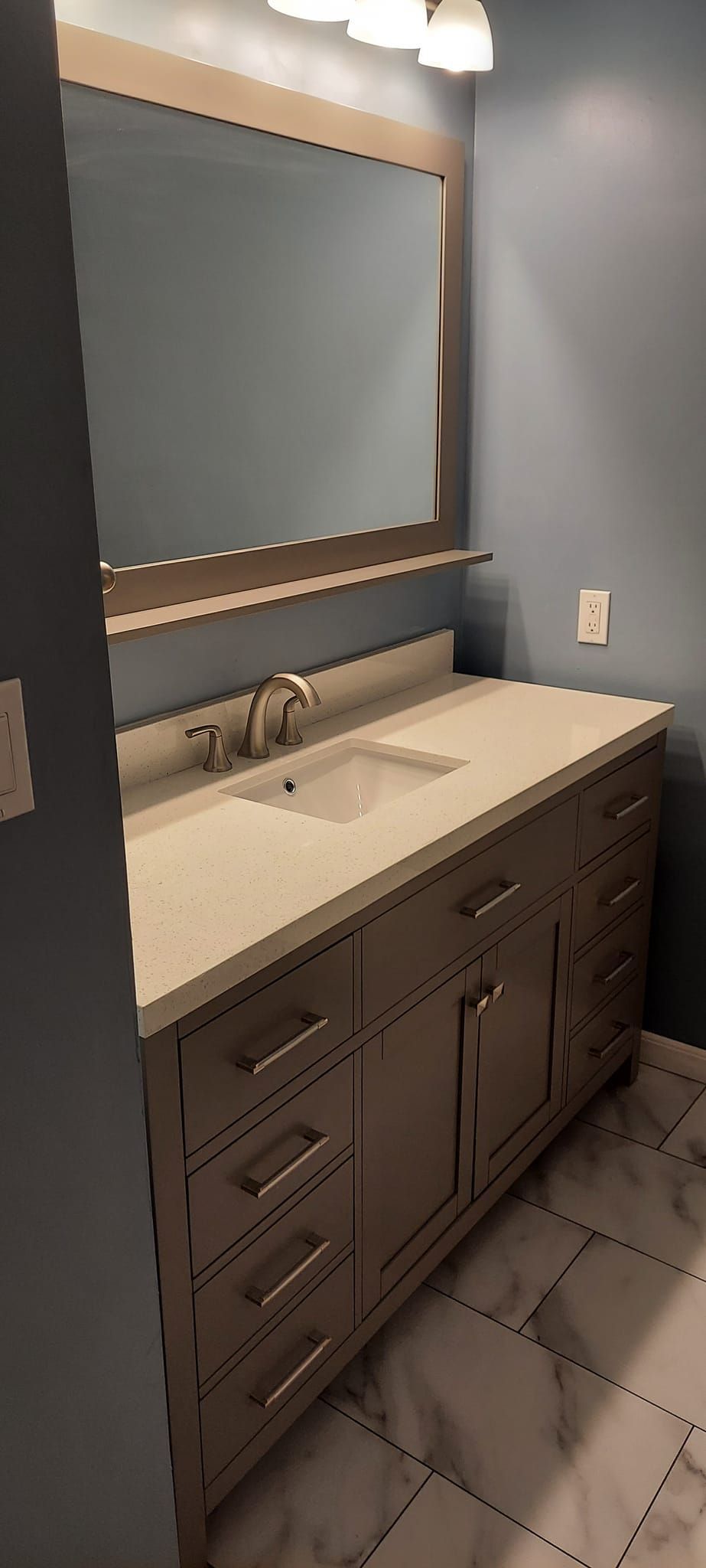 A bathroom with a sink , mirror and cabinets.