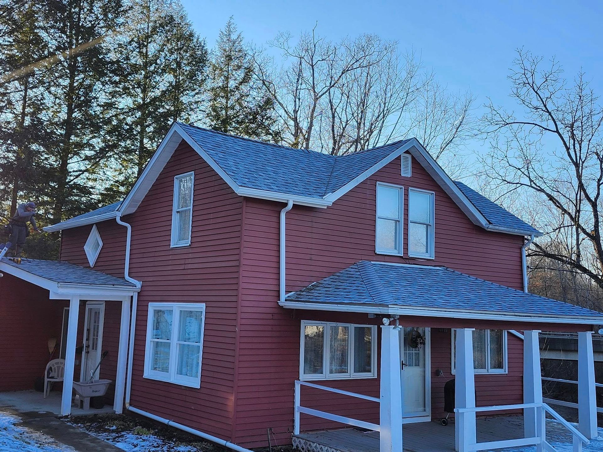 A red house with a blue roof and a porch