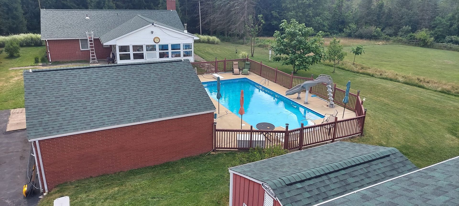 An aerial view of a house with a swimming pool in the backyard.
