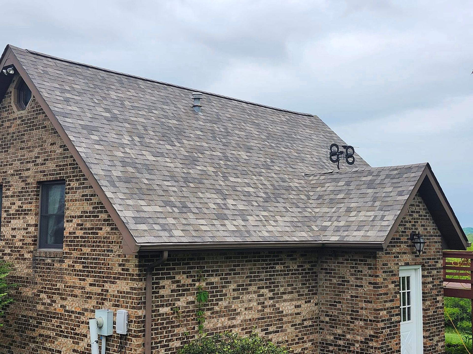 A brick house with a gray roof and a white door.