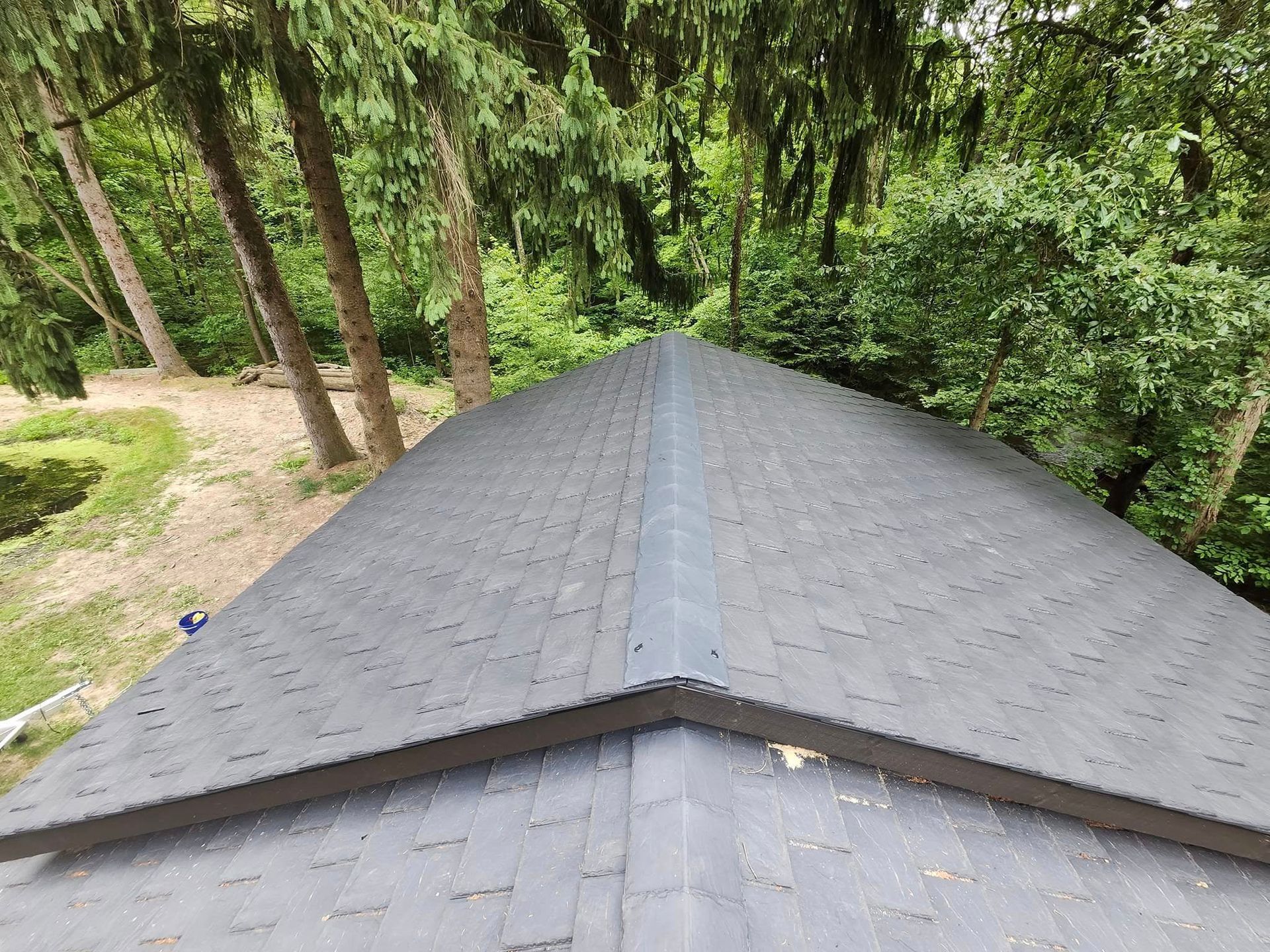 A close up of a roof with trees in the background.