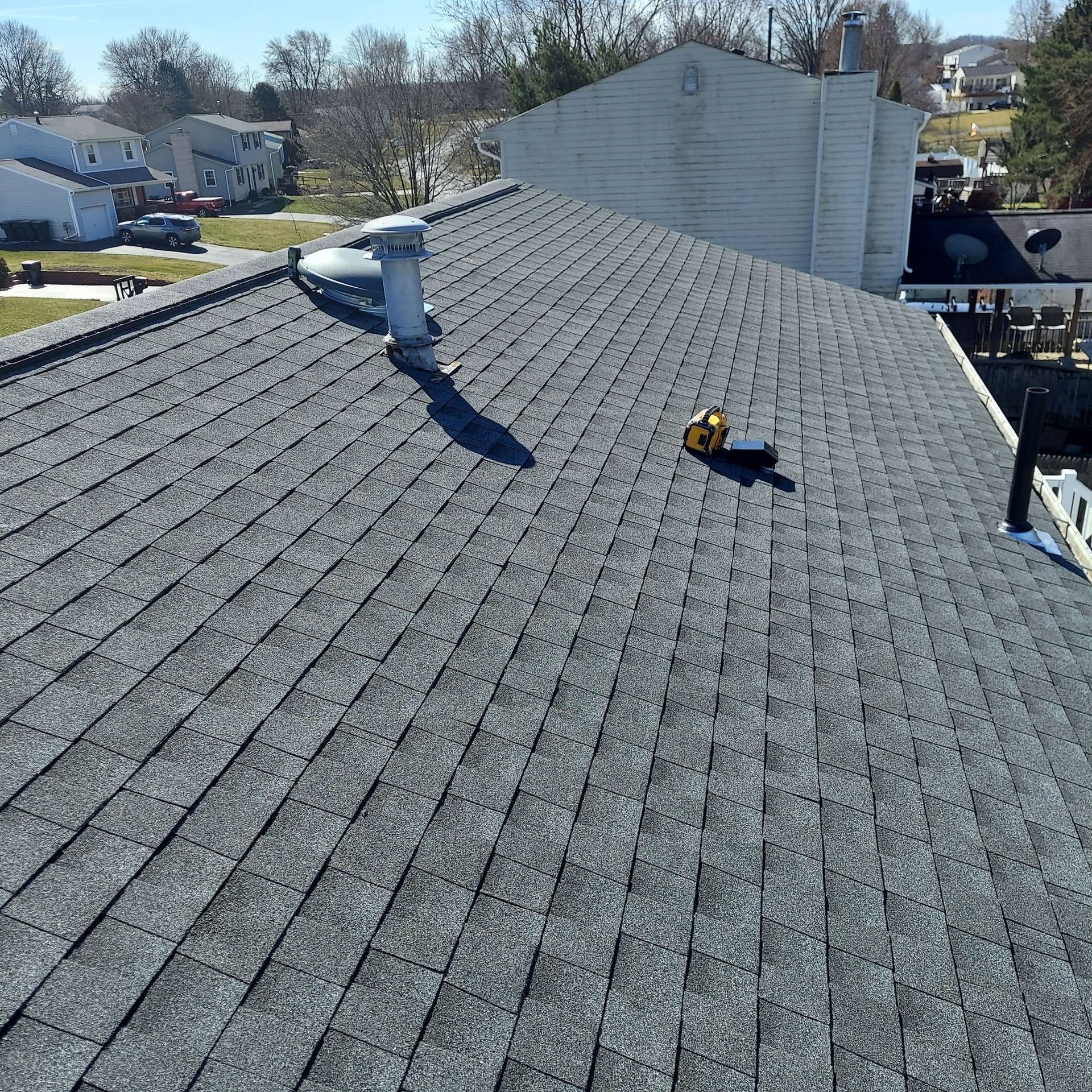 A roof with shingles and a ladder on top of it.
