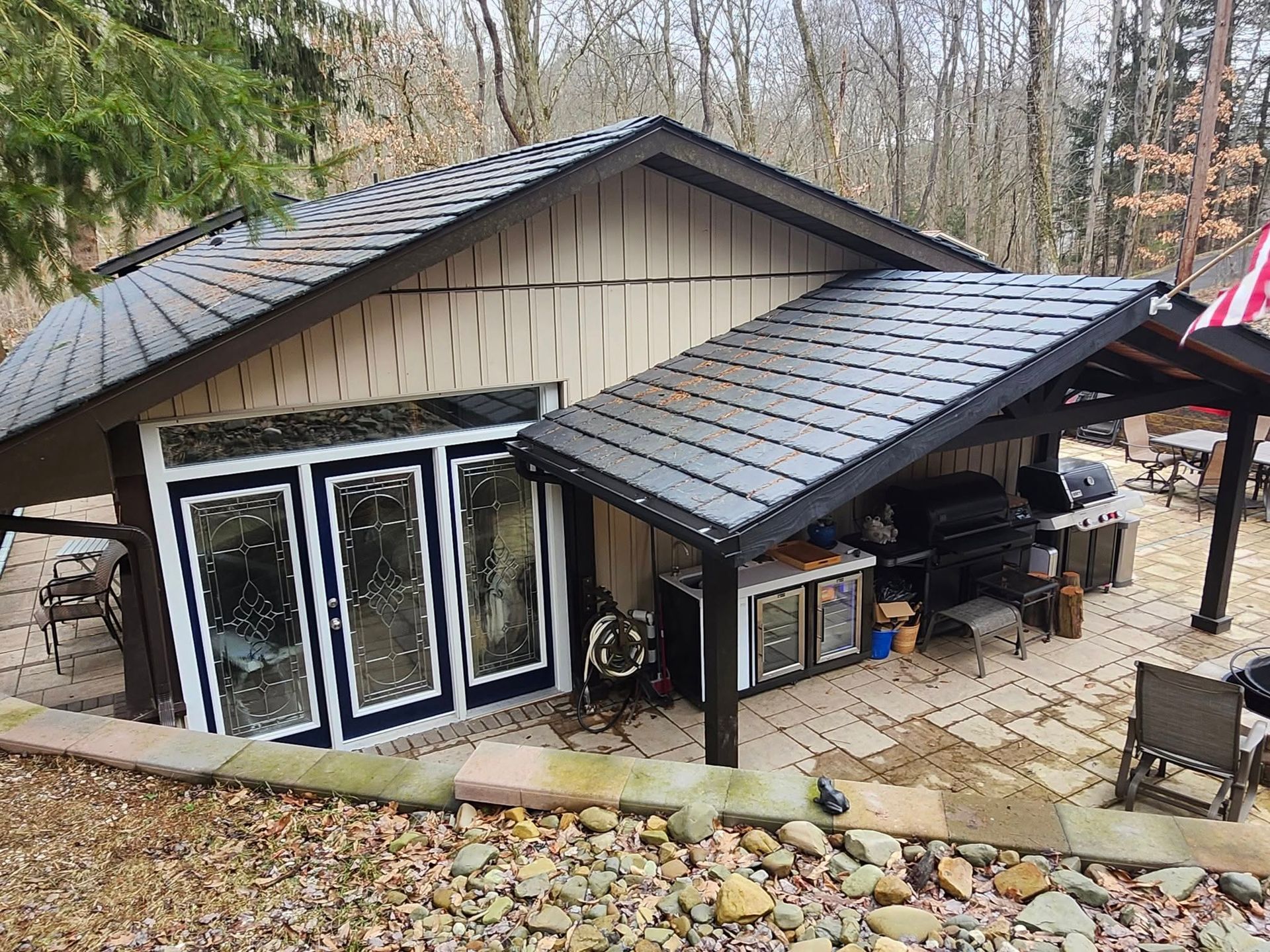 A house with a covered patio and a flag on the roof.