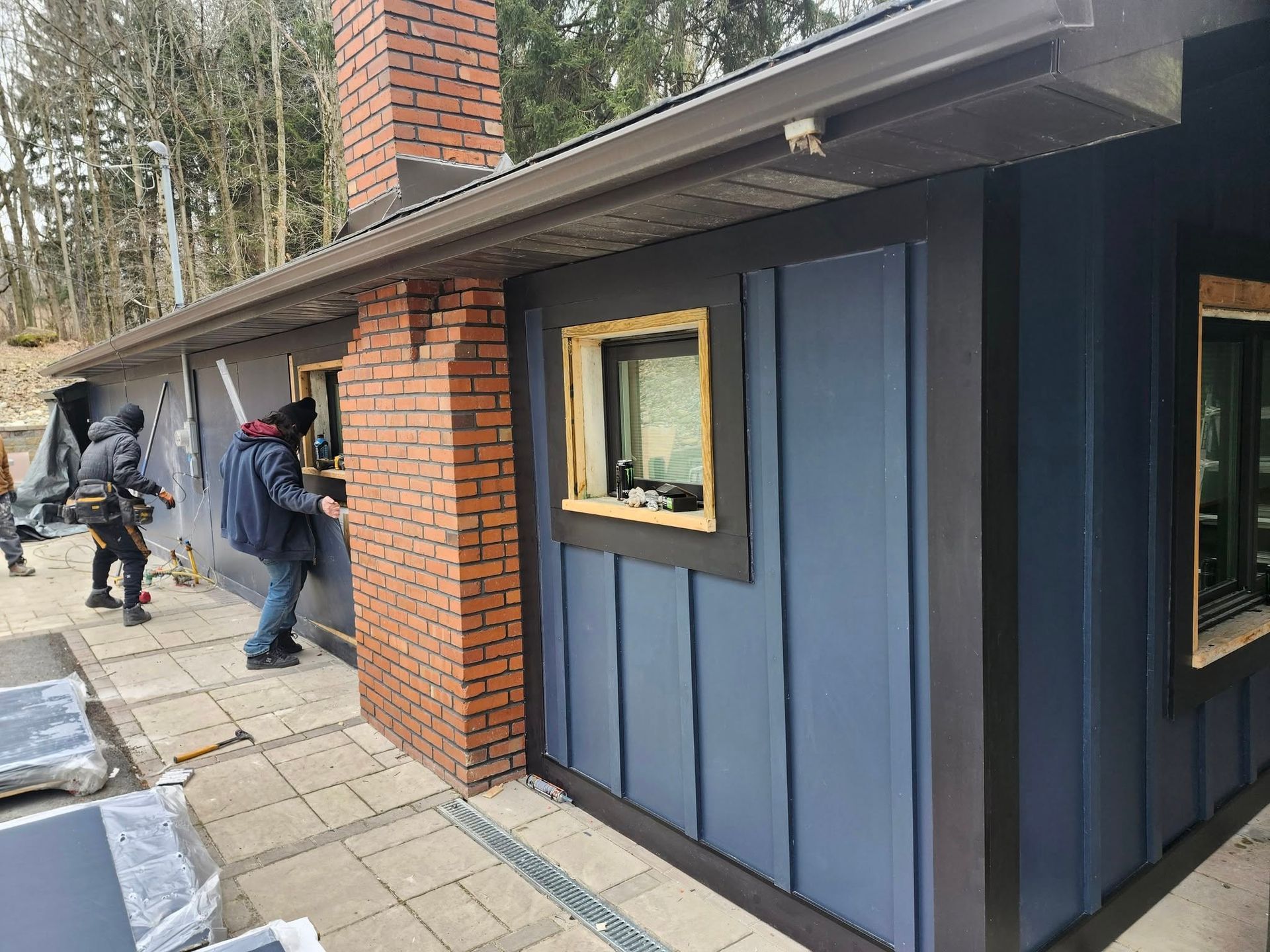 A group of people are working on the side of a house.