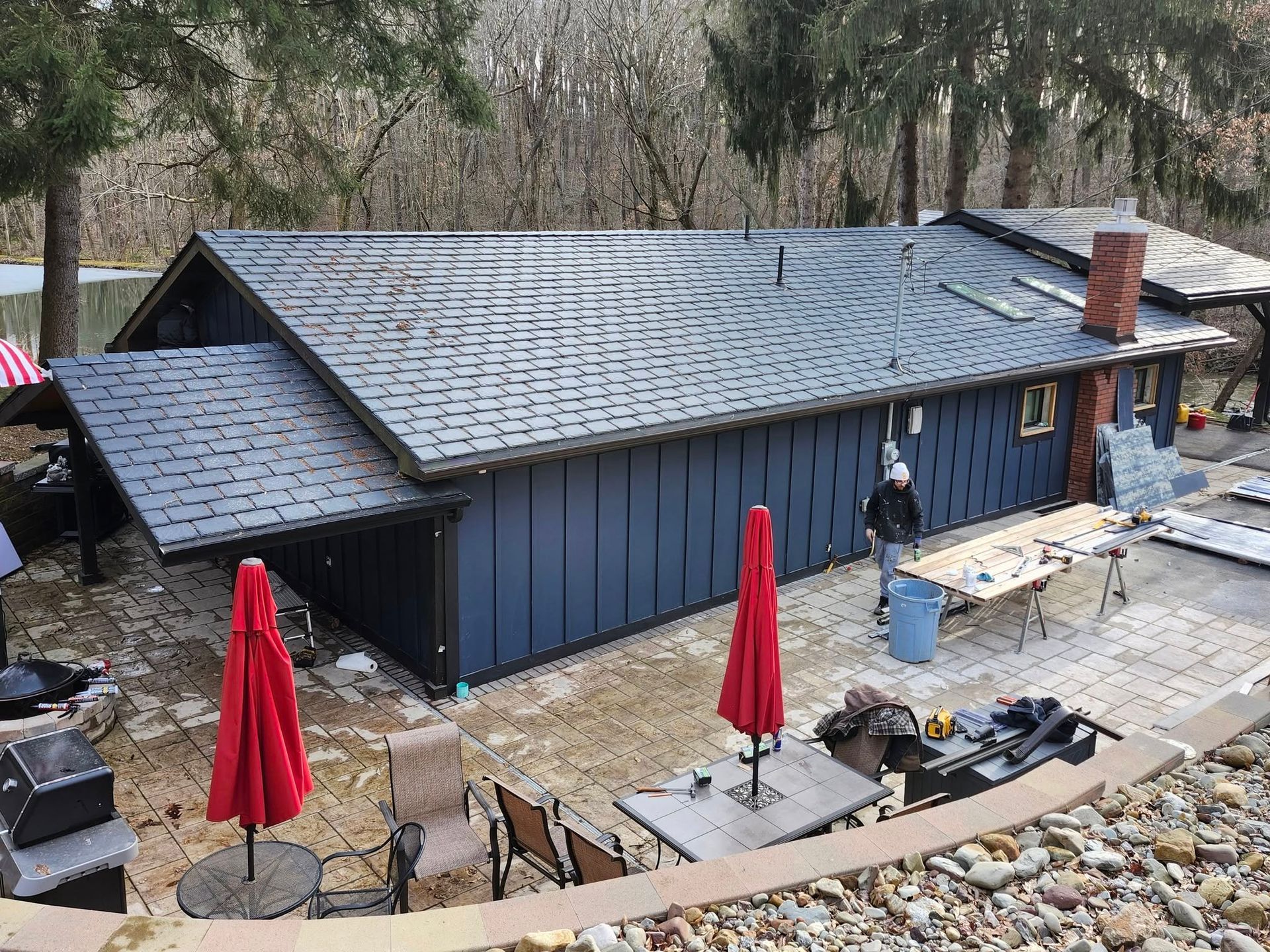 A blue house with a black roof is being remodeled.