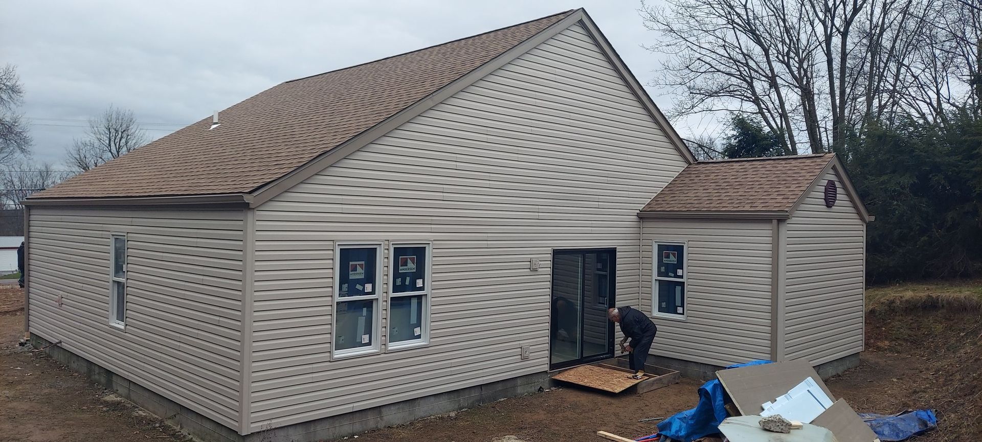 A man is standing in front of a house that is being built.