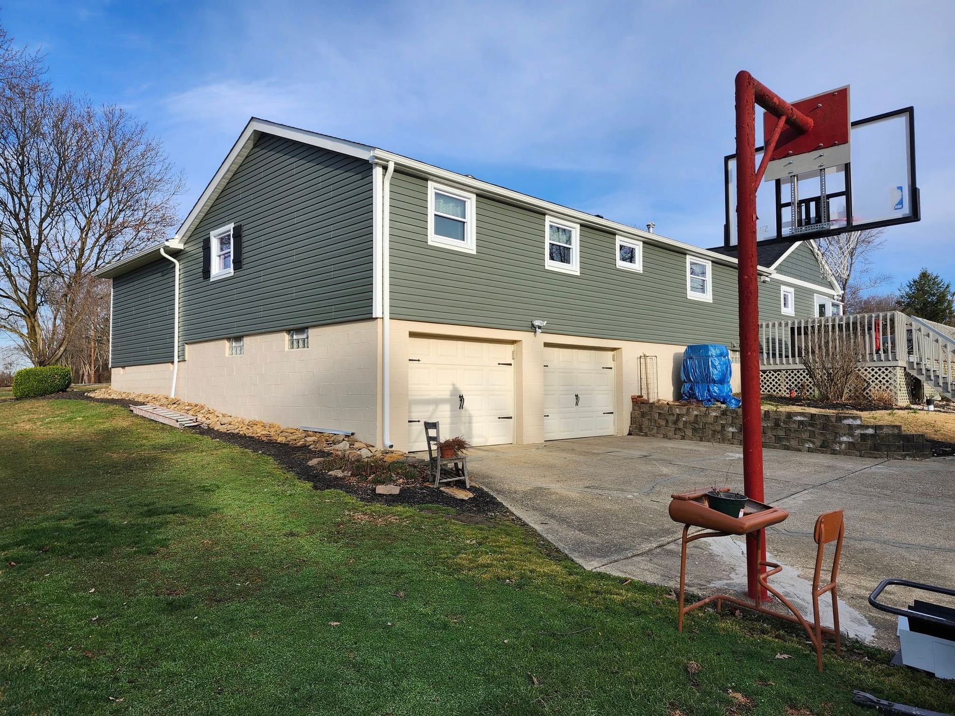 A large house with a basketball hoop in front of it.