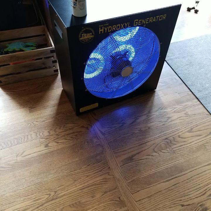 A hydroxyl generator is sitting on a wooden floor
