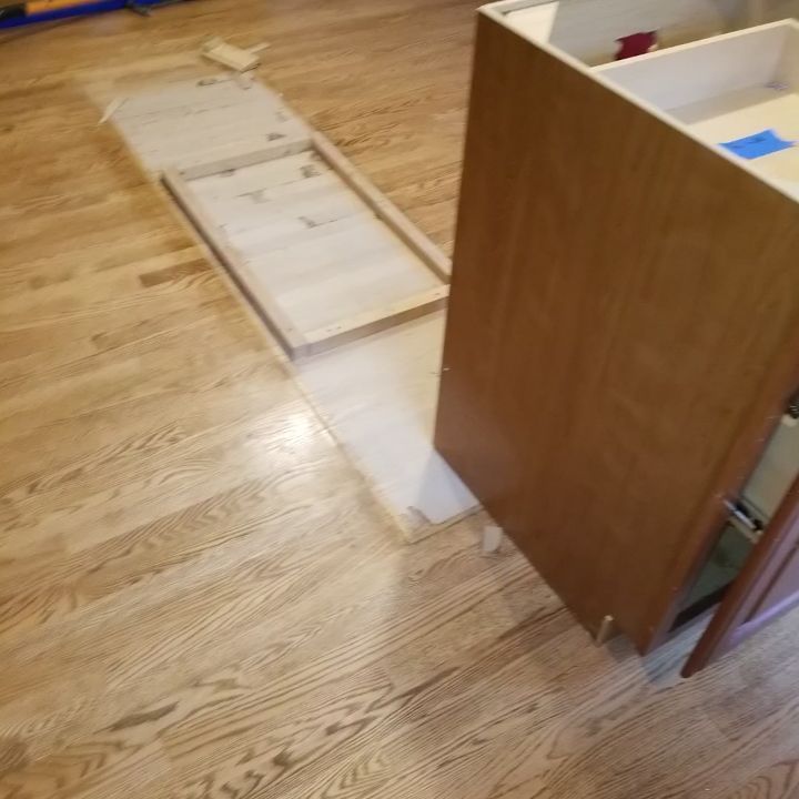 A wooden cabinet is sitting on top of a wooden floor.