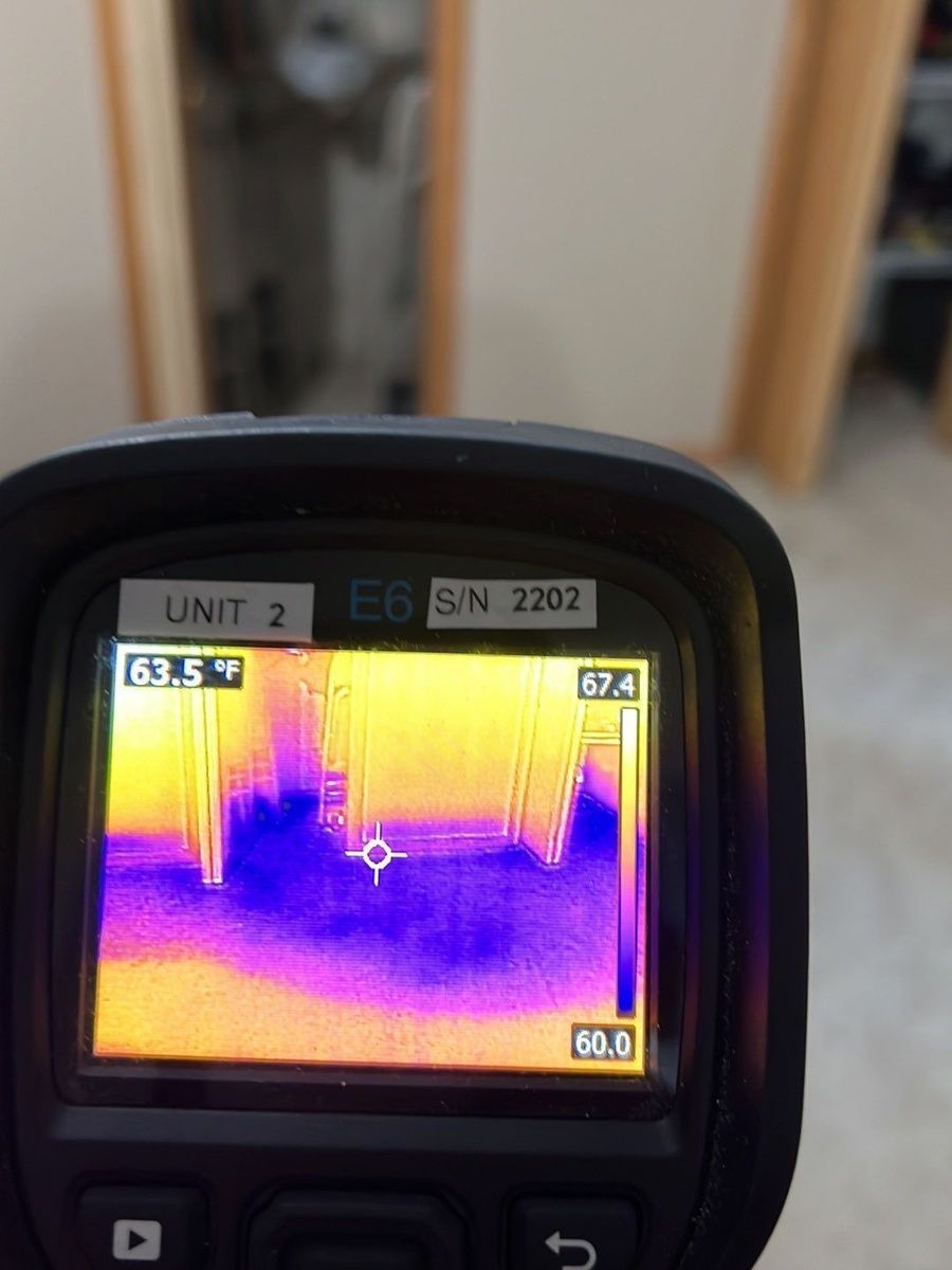 A person is holding a thermal camera that says unit 2 on it