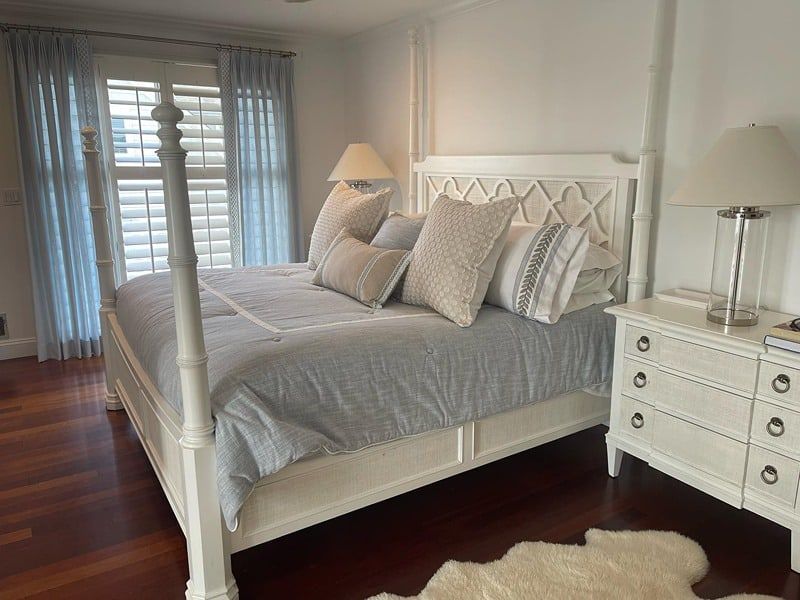 A bedroom with blue and cream bedding and window shutters