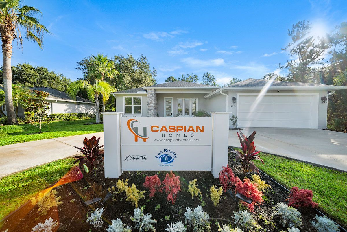 A white house with a sign in front of it that says caspian