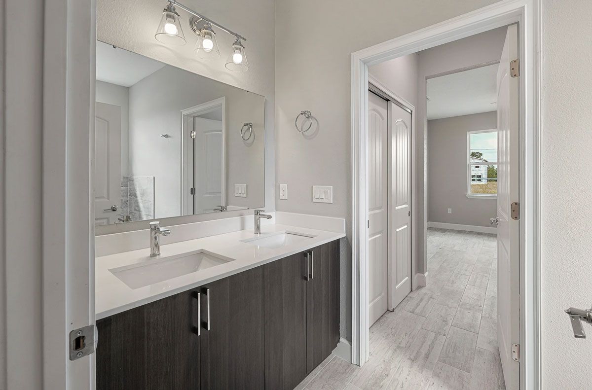 A bathroom with two sinks and a large mirror.