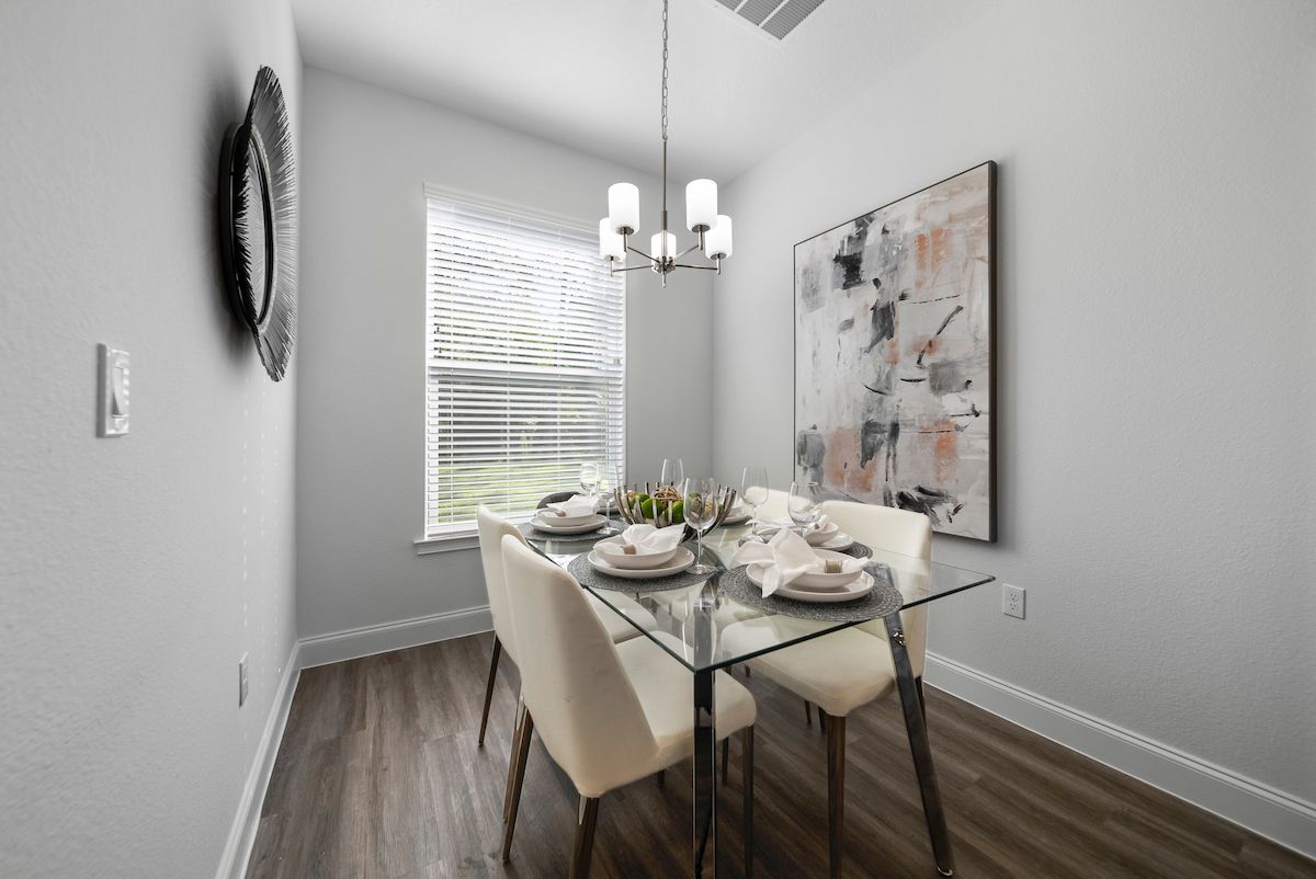 A dining room with a glass table and chairs and a chandelier.