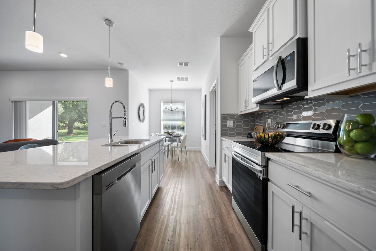 A kitchen with white cabinets and stainless steel appliances.