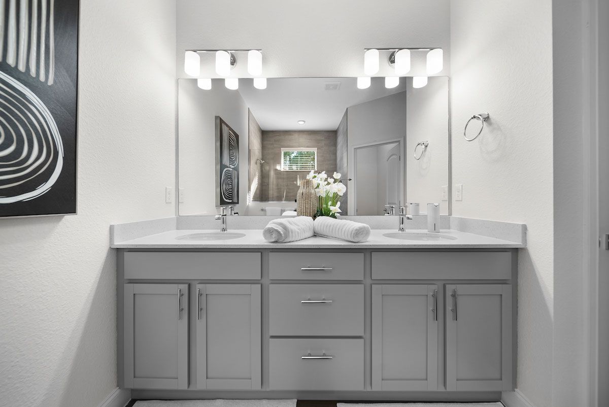 A bathroom with two sinks and a large mirror.