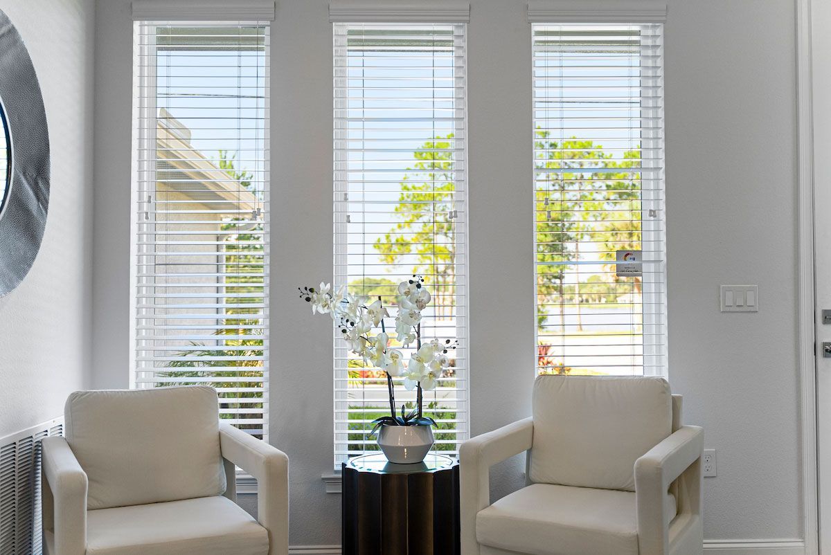 A living room with two chairs and a vase of flowers.