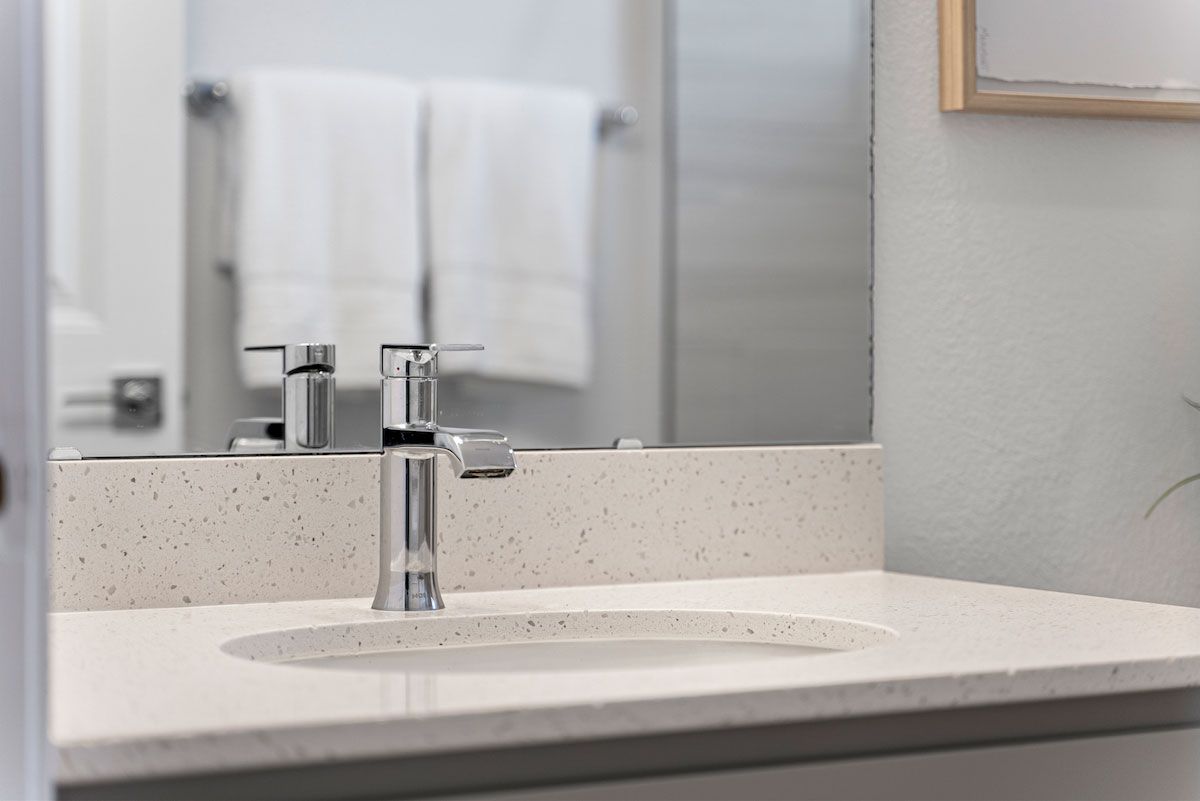 A bathroom sink with a faucet and a mirror.