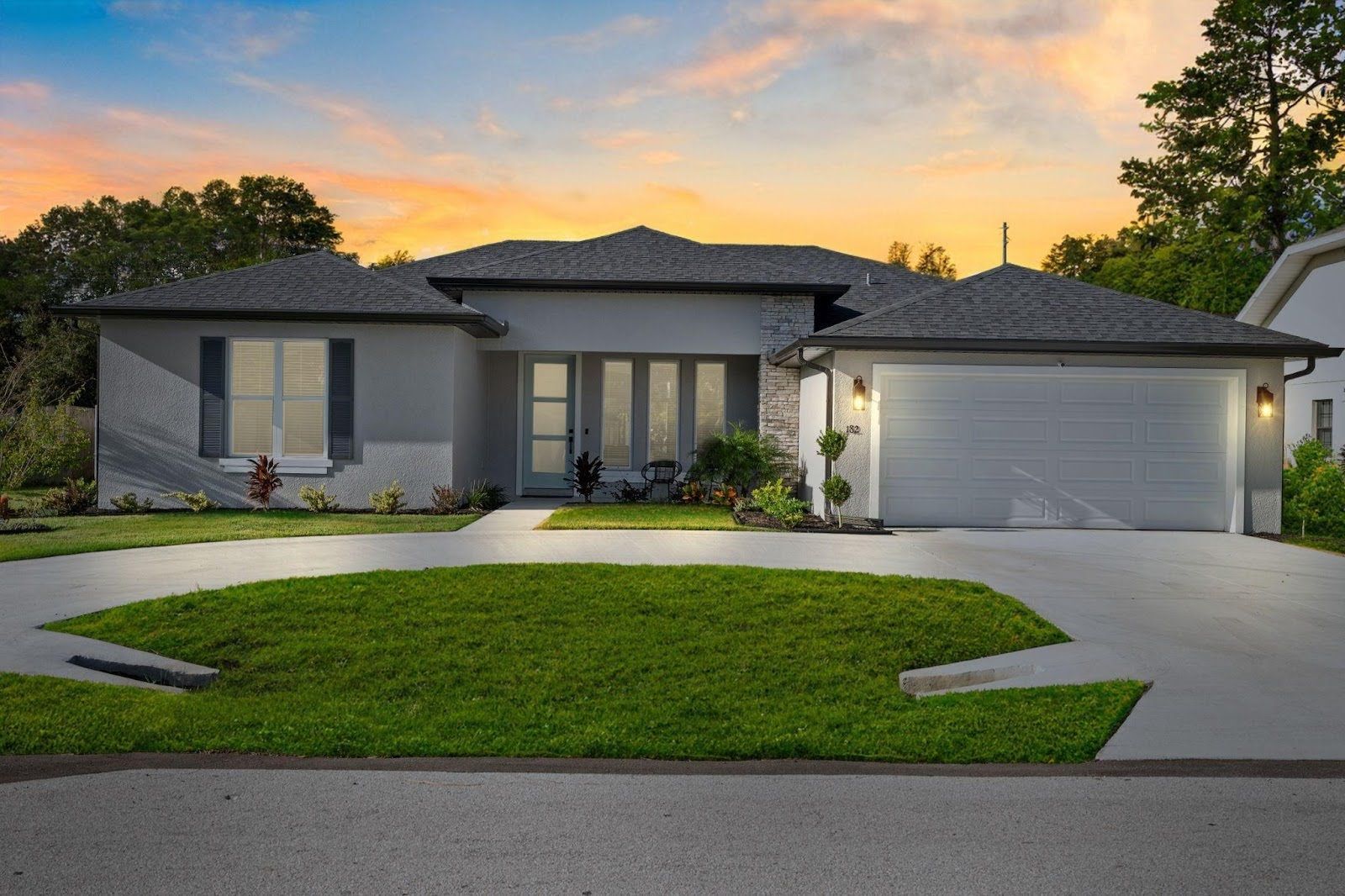 A young couple talks with a real estate agent in front of a new home in Palm Coast