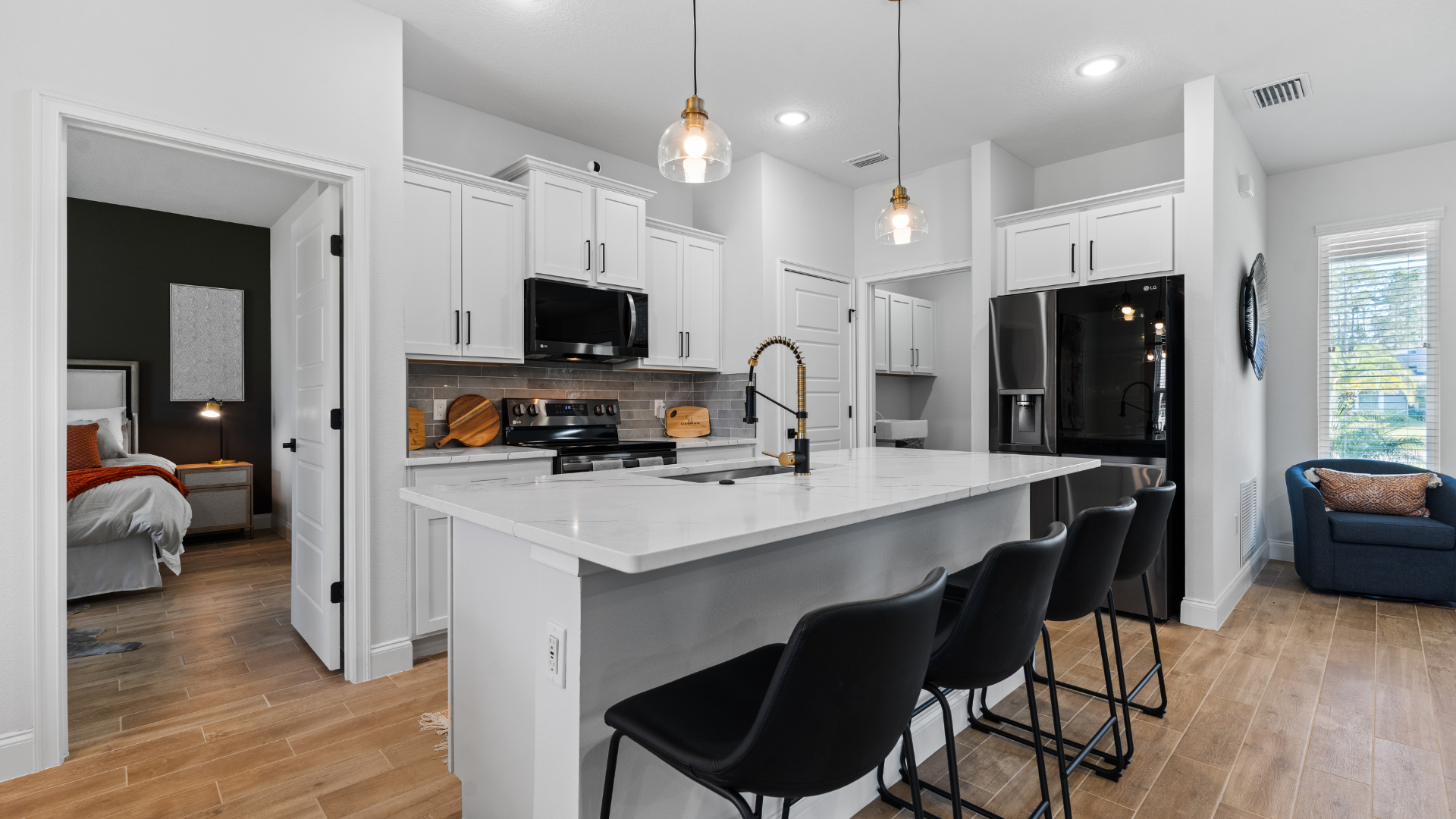 Cozy Caspian Homes Grand Alborz home interior with natural wood floors, stone countertops, and large sliding doors opening to a garden, featuring warm natural lighting and an editorial-style design