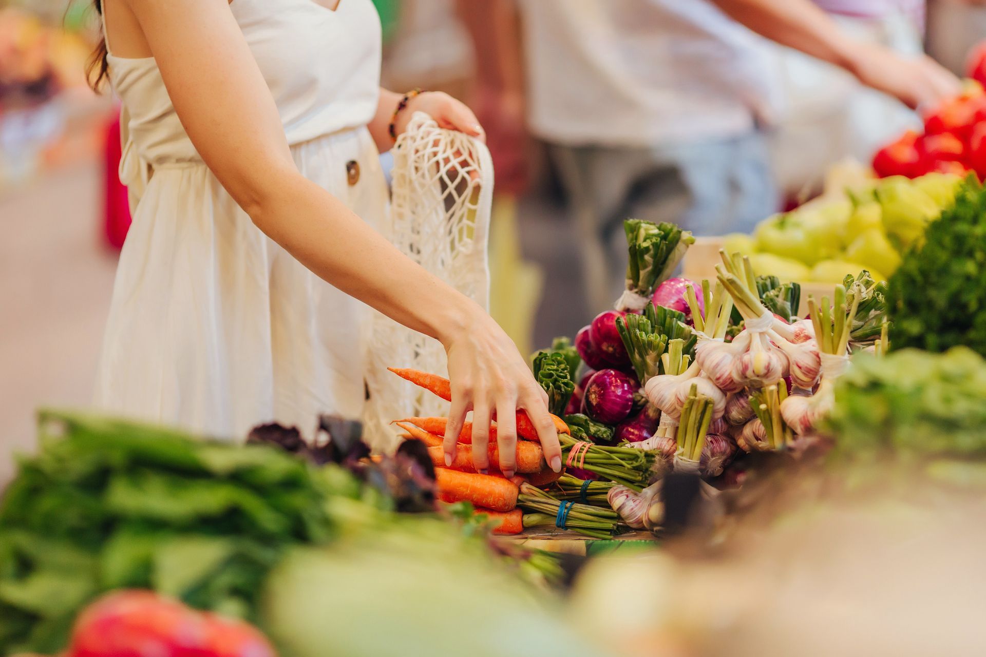 woman getting veggies at the farmers market
