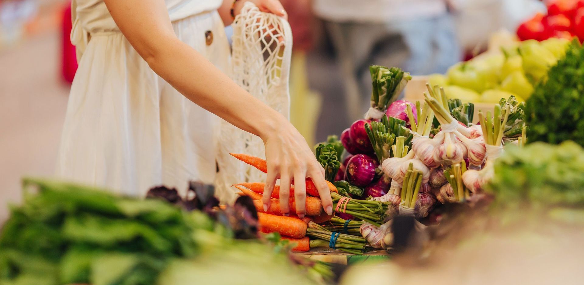 young woman getting veggies at a farmers market