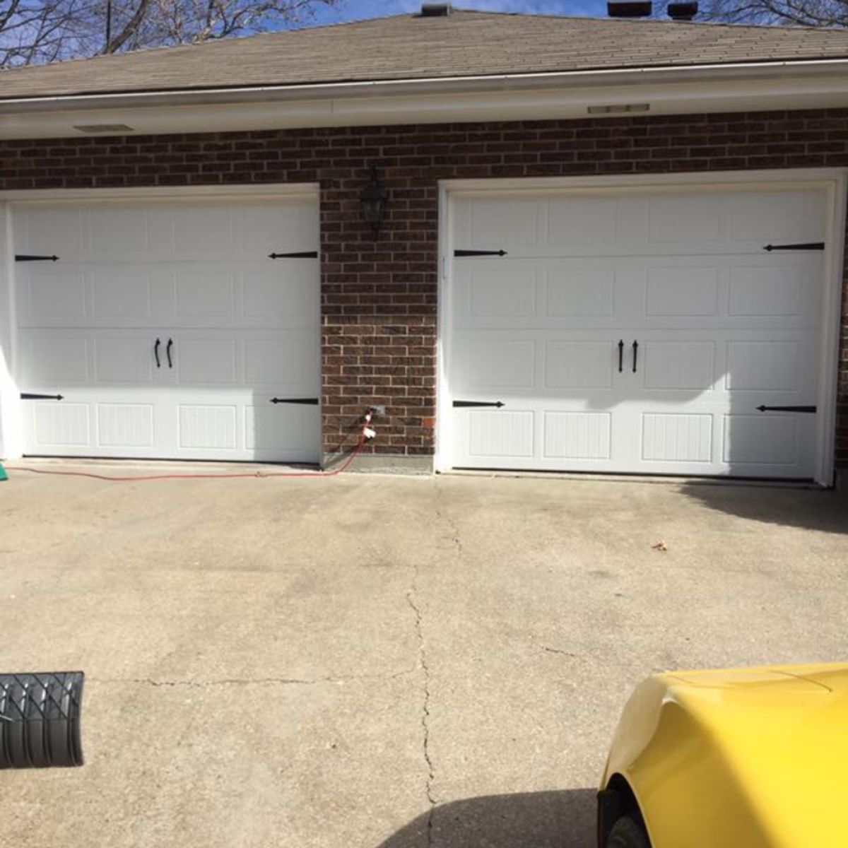 Homeowner comparing garage door styles and materials for residential installation in Excelsior Springs MO