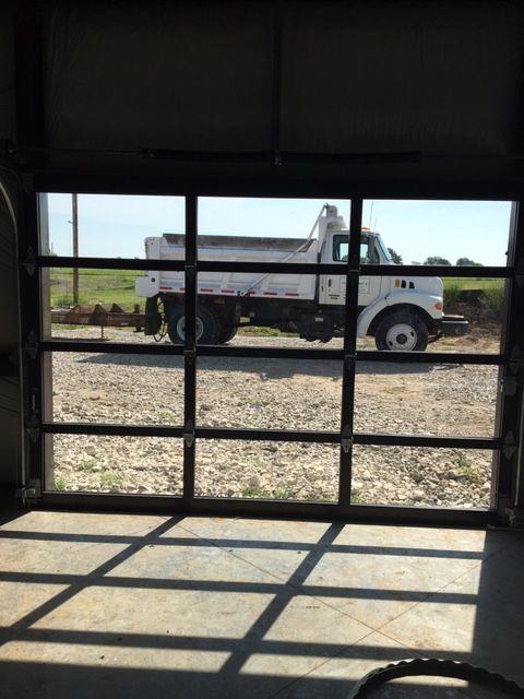 A dump truck is parked in front of a glass garage door