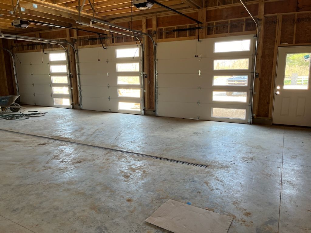 A garage with a lot of doors and a wheelbarrow in it