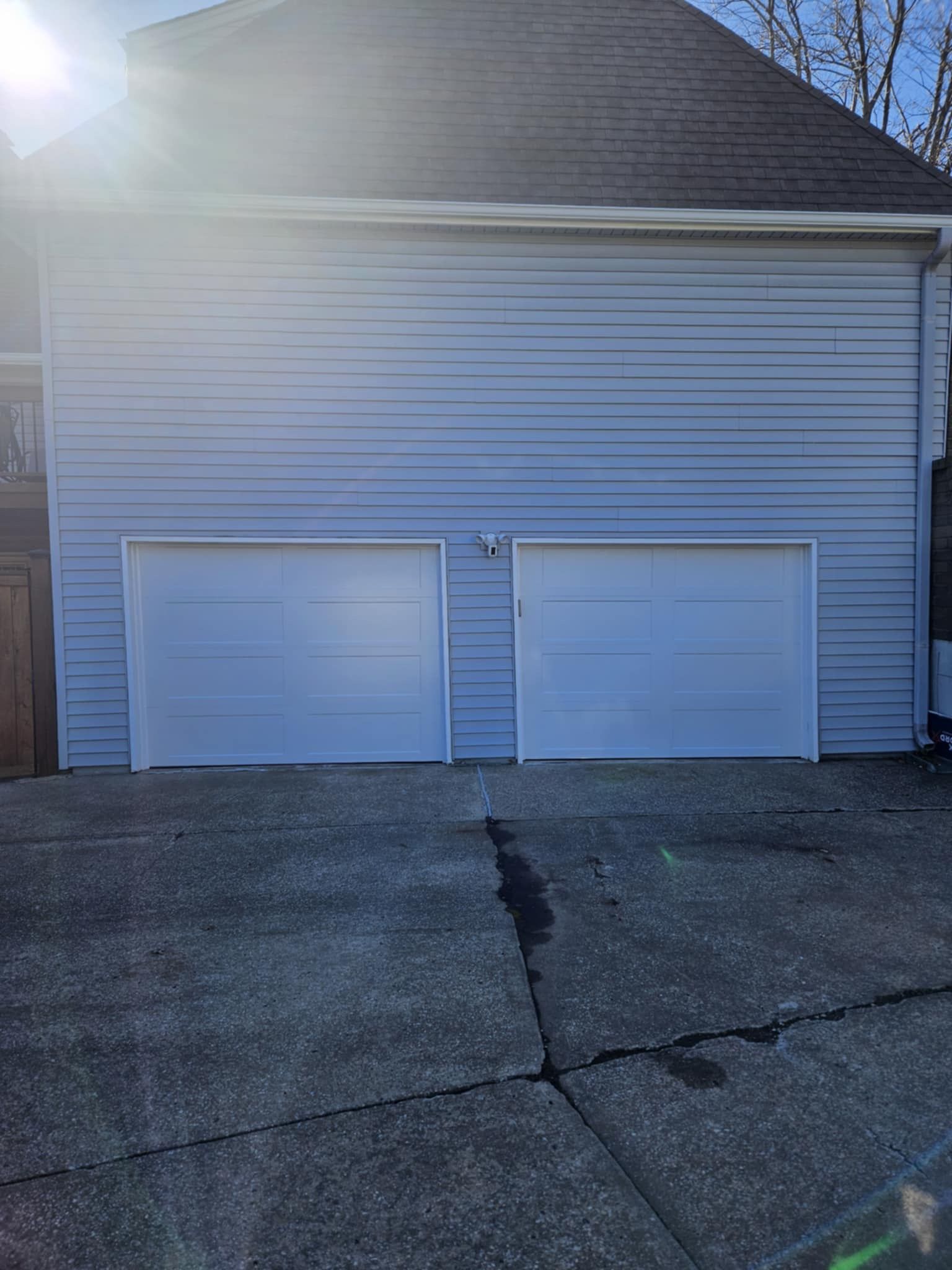 There are two garage doors on the side of a house.