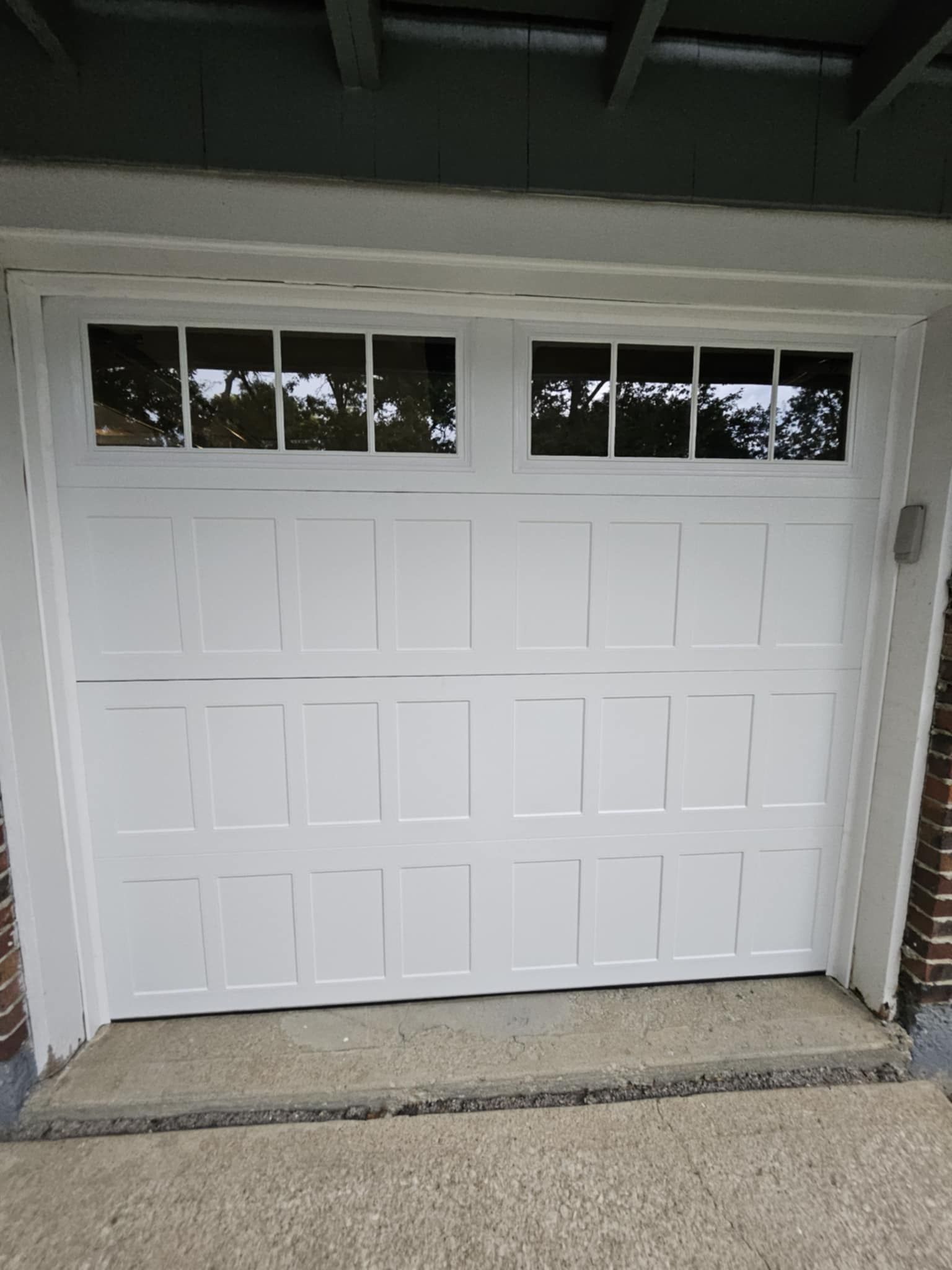A white garage door with a window on the side of it.