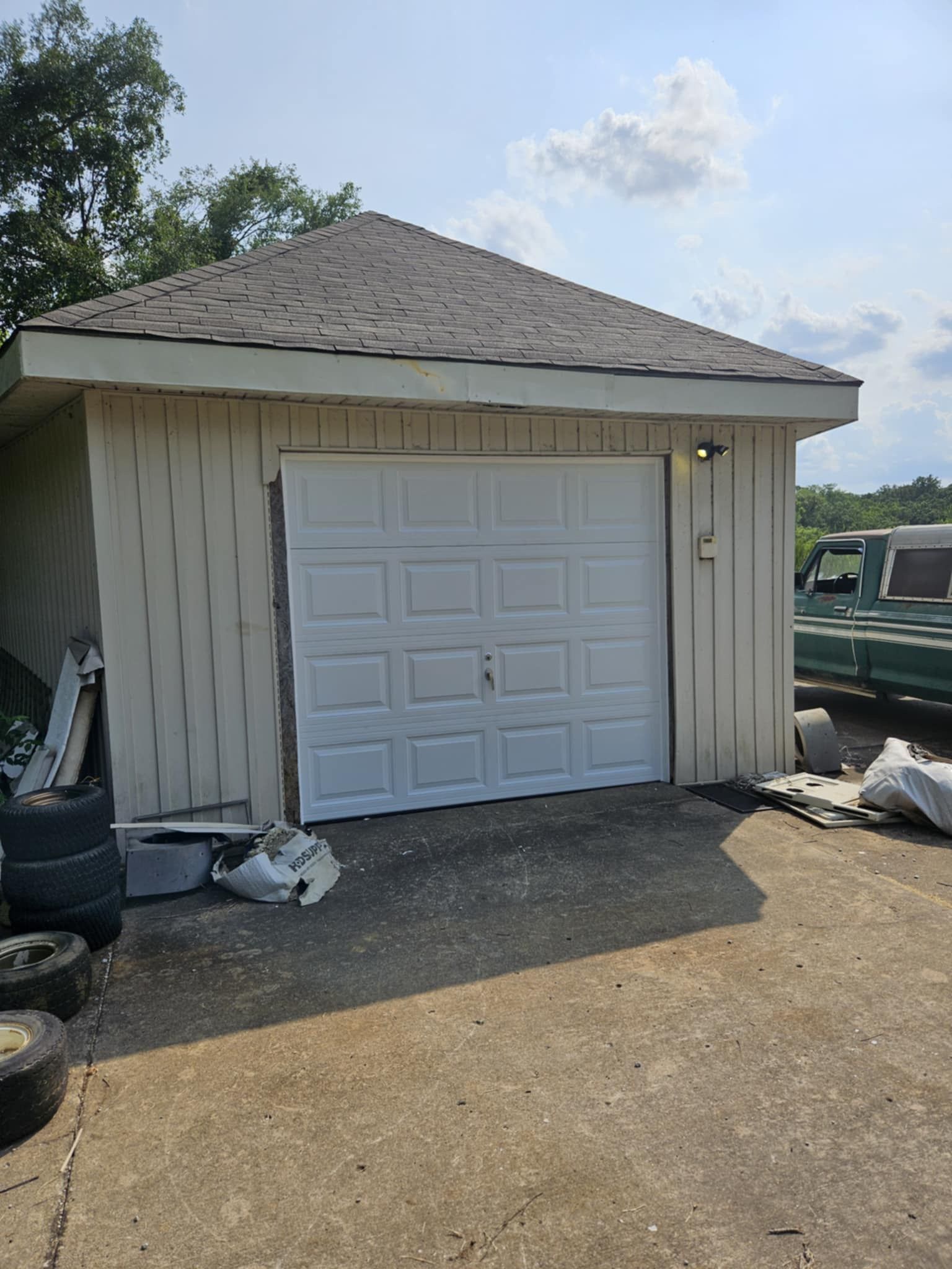 A garage with a white garage door and a truck parked in front of it.