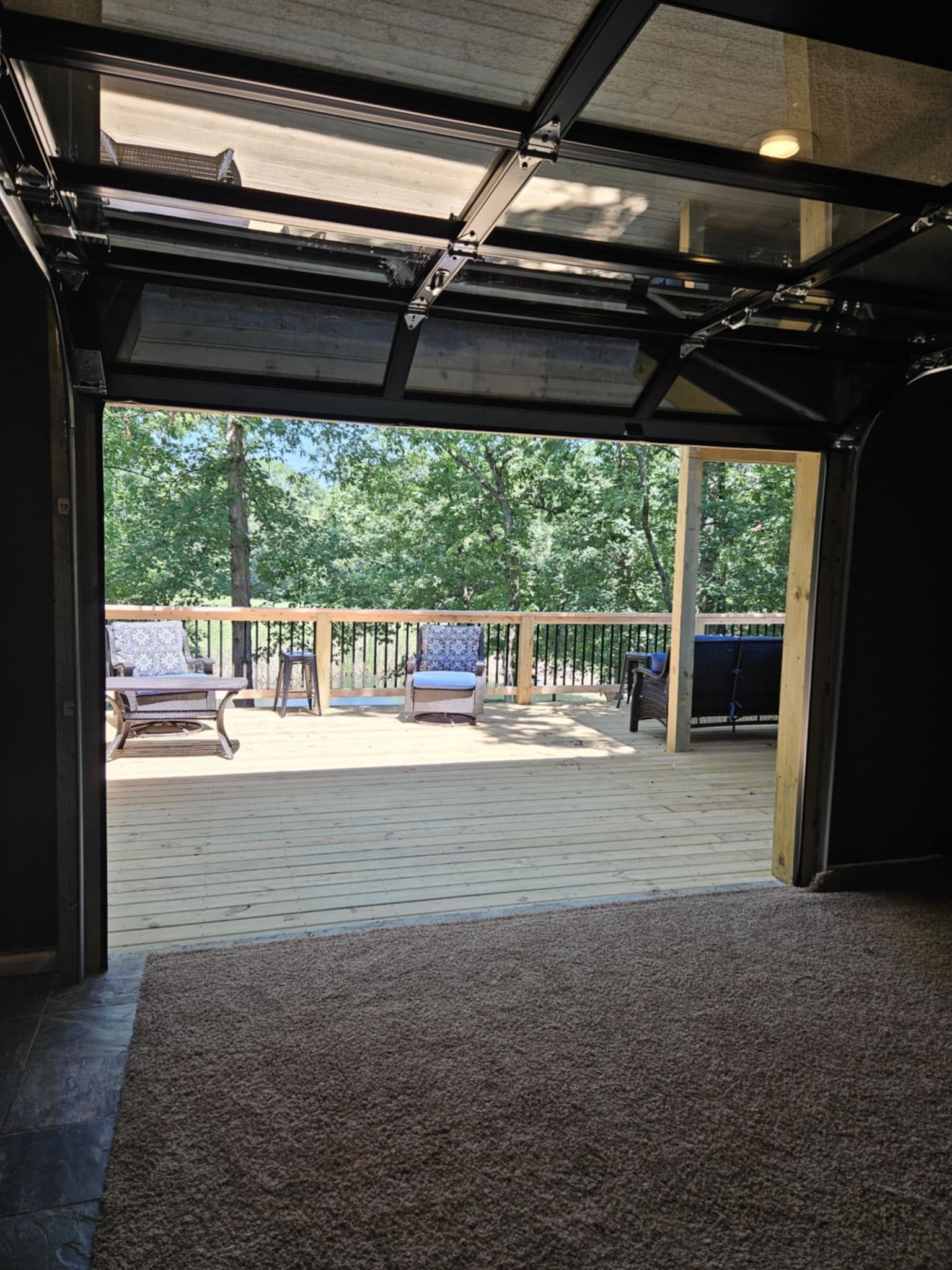 A view of a deck from inside a garage door.