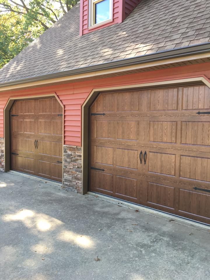 There are two garage doors on the side of a house.