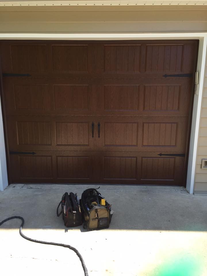 A garage door with a tool bag in front of it