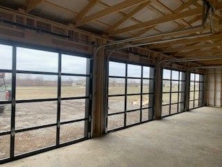A garage with a lot of windows and a car parked in the background.